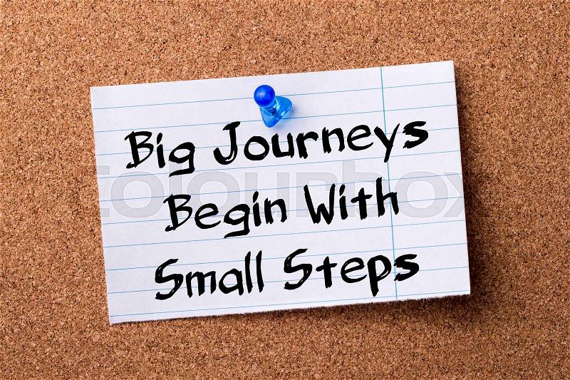 Big Journeys Begin With Small Steps - teared note paper pinned on bulletin board - horizontal image, stock photo