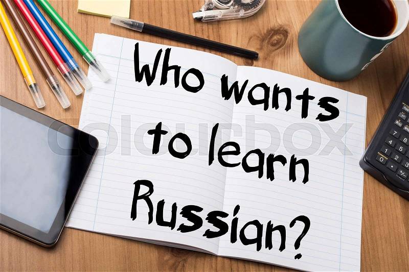Who wants to learn Russian? - Note Pad With Text On Wooden Table - with office tools, stock photo