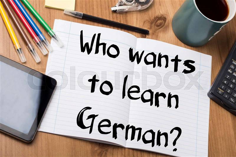 Who wants to learn German? - Note Pad With Text On Wooden Table - with office tools, stock photo