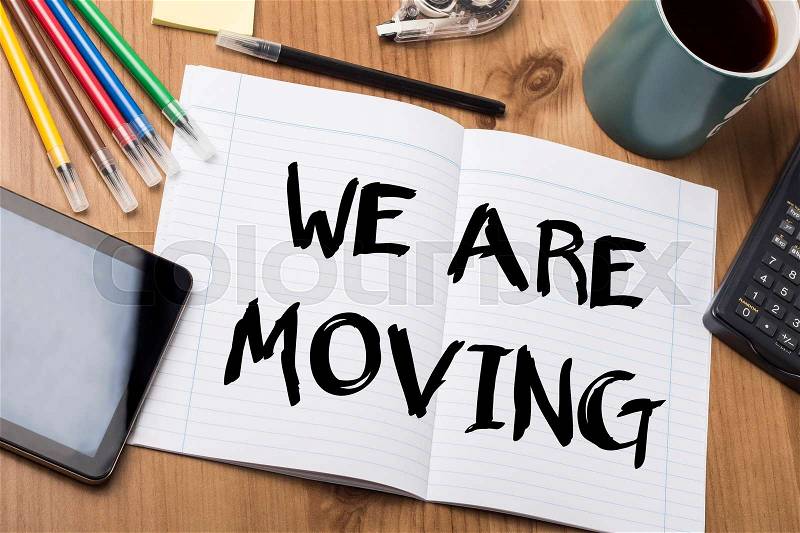 WE ARE MOVING - Note Pad With Text On Wooden Table - with office tools, stock photo
