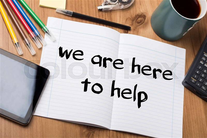 We are here to help - Note Pad With Text On Wooden Table - with office tools, stock photo