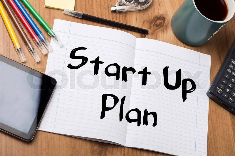 Start Up Plan - Note Pad With Text On Wooden Table - with office tools, stock photo