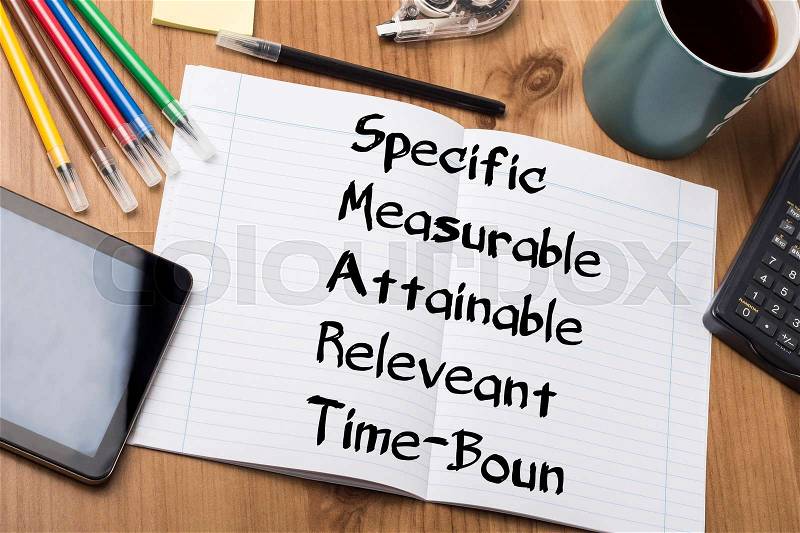 Specific Measurable Attainable Releveant Time-Bound SMART - Note Pad With Text On Wooden Table - with office tools, stock photo