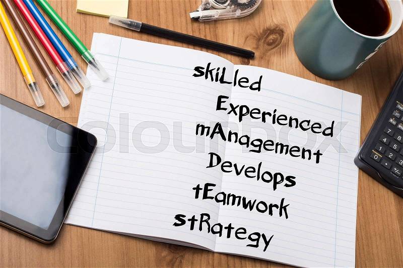 SkiLled Experienced mAnagement Develops tEamwork stRategy LEADER - Note Pad With Text On Wooden Table - with office tools, stock photo