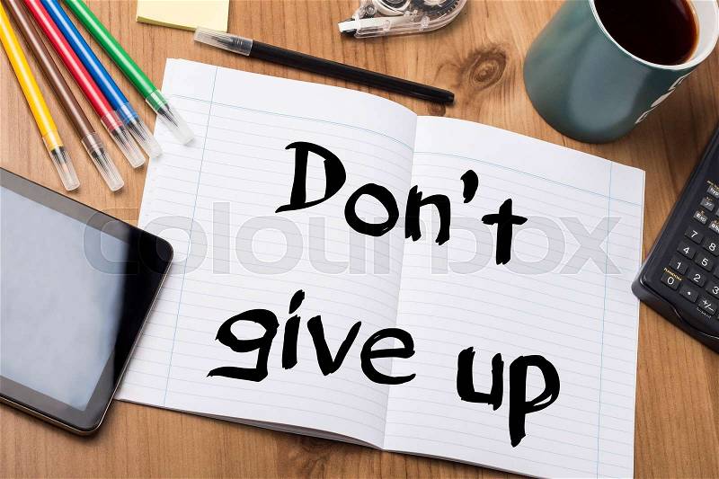 Don’t give up - Note Pad With Text On Wooden Table - with office tools, stock photo