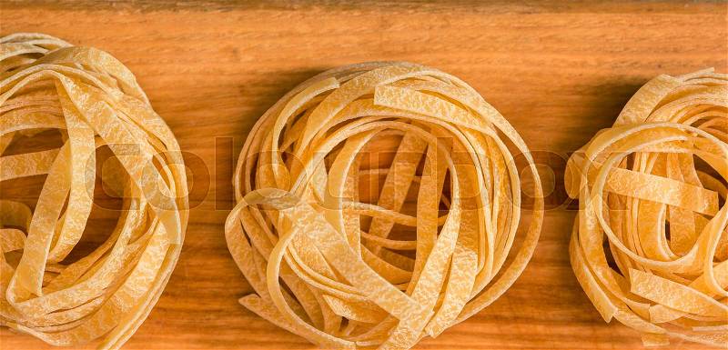 The dry Italian pasta on gray wooden table background, stock photo