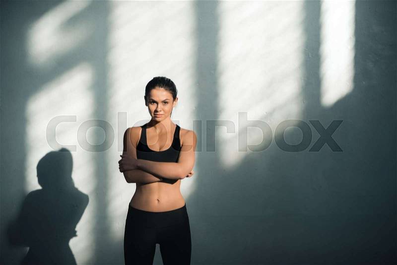 Portrait of sporty woman in sportive clothes with shadows, stock photo