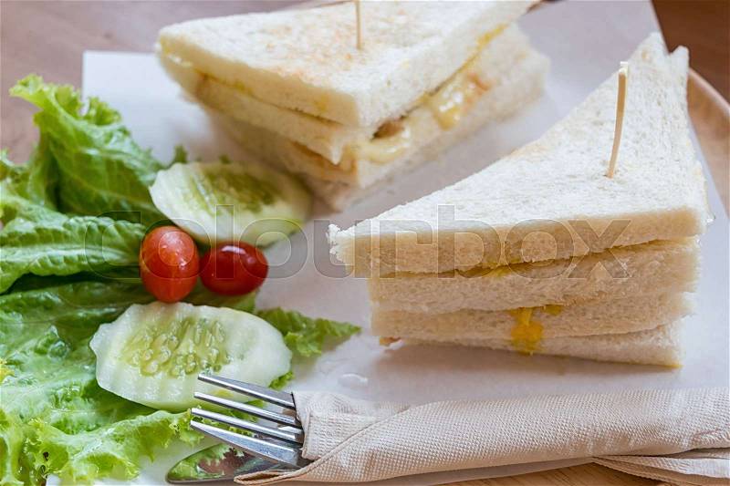 Slice ham cheese egg sandwich breakfast with fresh vegetable cucumber on wooden table ,selective focus , stock photo