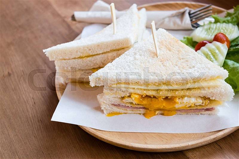 Slice ham cheese egg sandwich breakfast with fresh vegetable cucumber on wooden table ,selective focus , stock photo
