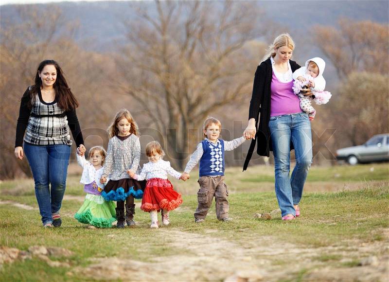 Group of kids with parents walking outdoors, stock photo
