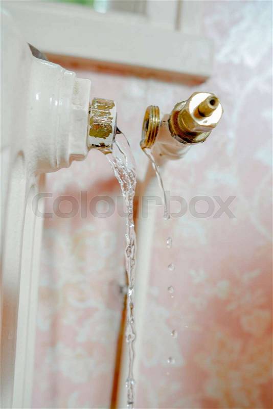 Pipe burst off of a radiator, leaking water, stock photo