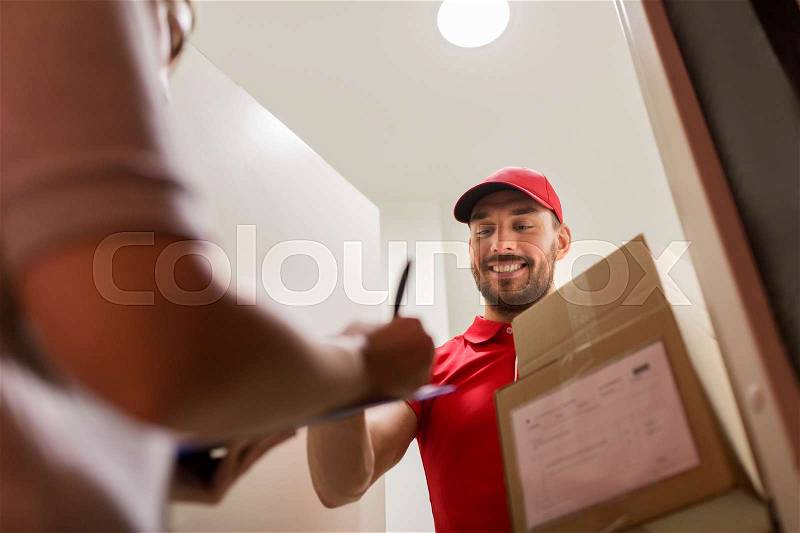 Delivery, mail, people and shipping concept - happy man with clipboard delivering parcel boxes to customer signing form at home, stock photo