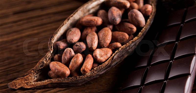 Cocoa pod and cocoa beans on the wooden table, stock photo