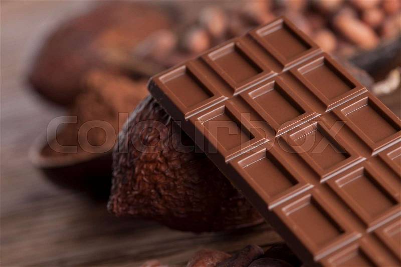 Chocolate bar, candy sweet, cacao beans and powder on wooden background, stock photo