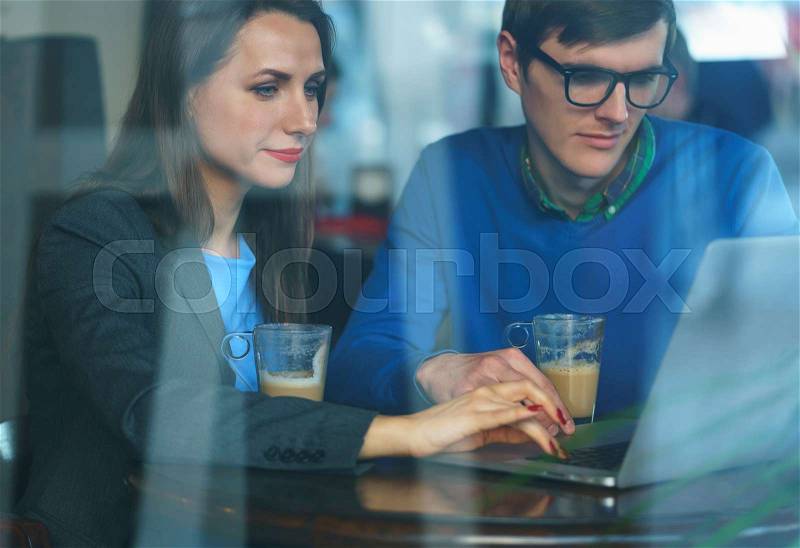 Beautiful young woman and man negotiating in a cafe - modern business concept, stock photo
