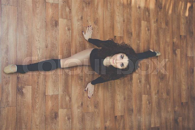 Young flexible sportive beautiful woman is doing stretching exercise for legs , view from above, stock photo