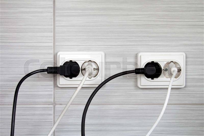 Electrical plugs connected into the wall sockets, stock photo