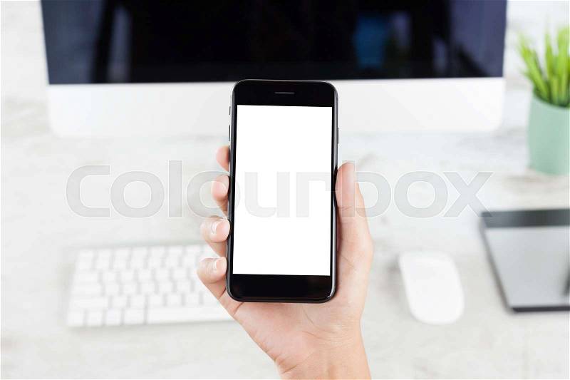 Close-up hand showing blank white screen over pc computer desk, stock photo