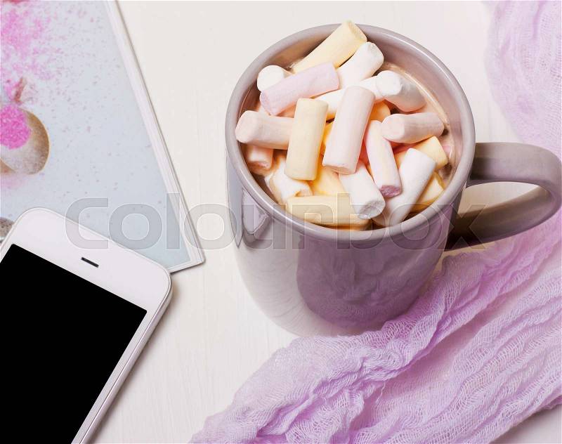 Mug coffee, cocoa with marshmallows and a phone on a white background, stock photo