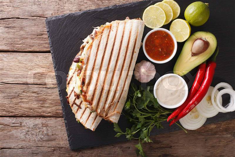 Mexican food: Quesadillas with beef, beans, avocado and cheese close-up on the table. horizontal view from above , stock photo
