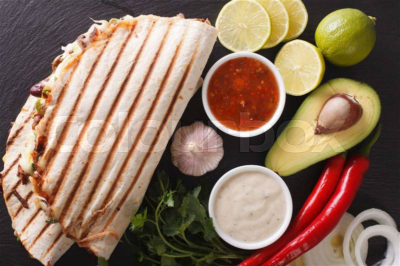 Quesadilla with minced beef, beans, avocado and cheese close-up on the table. horizontal view from above , stock photo