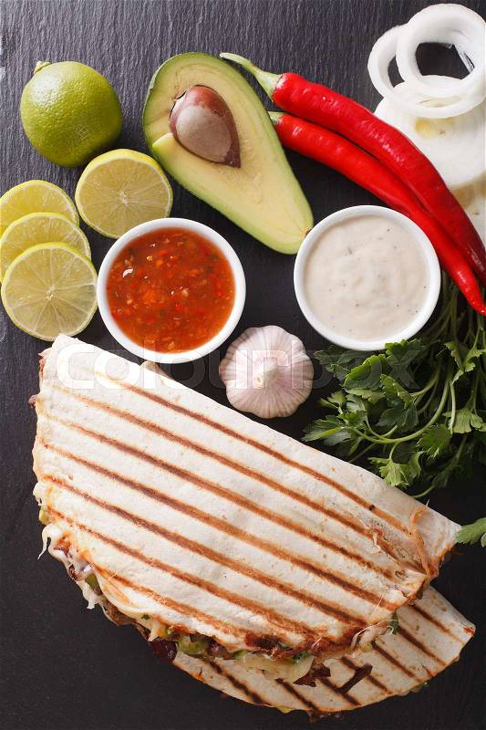 Mexican food: Quesadillas with beef, beans, avocado and cheese close-up on the table. vertical view from above , stock photo