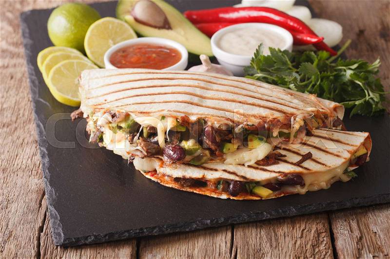 Quesadilla with minced beef, beans, avocado and cheese close-up on the table. horizontal , stock photo