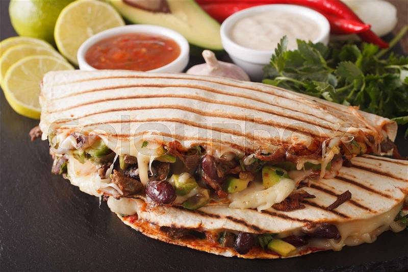 Mexican food: Quesadillas with beef, beans, avocado and cheese close-up on the table. horizontal , stock photo