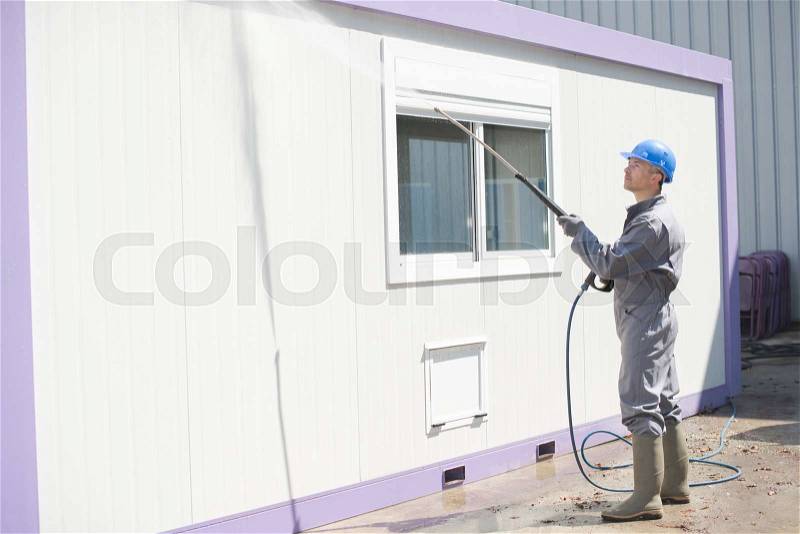 Industrial cleaner washing bungalow, stock photo