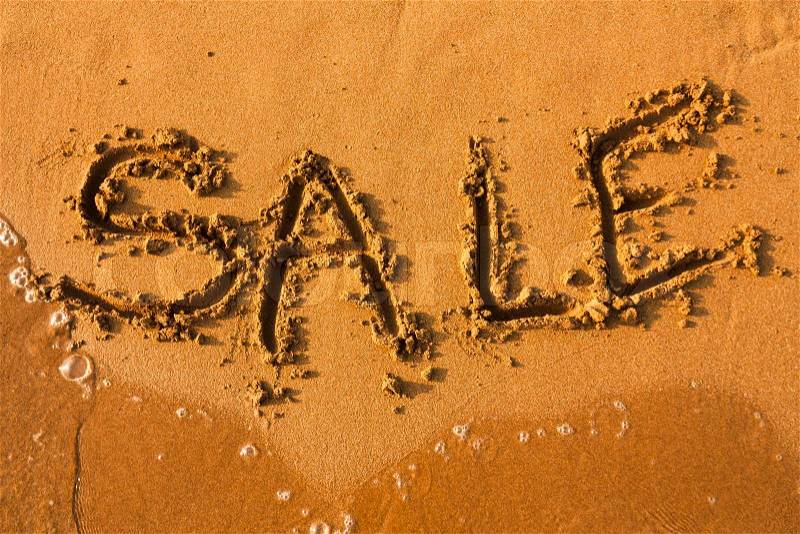 Word Sale on clean sand with water of sea Sale summer background, stock photo