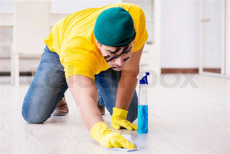 Man in military style cleaning the house, stock photo