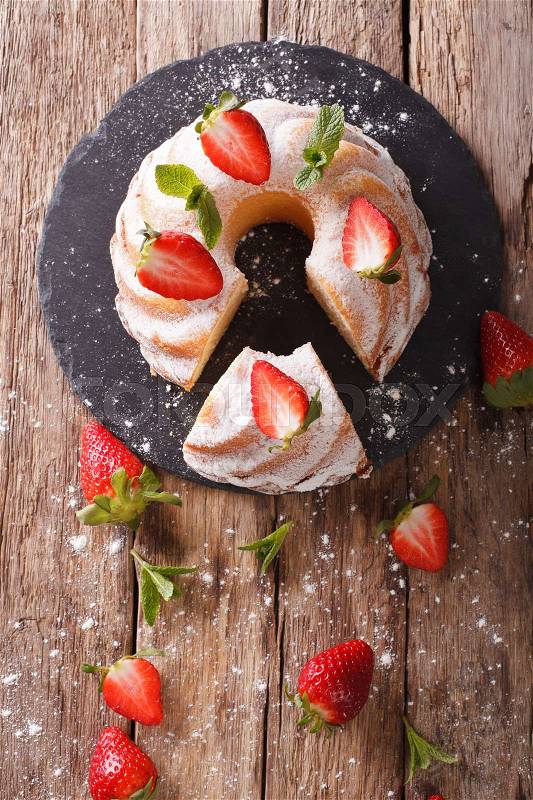 Pound Cake cake with mint and strawberry close-up on the table. Vertical view from above , stock photo