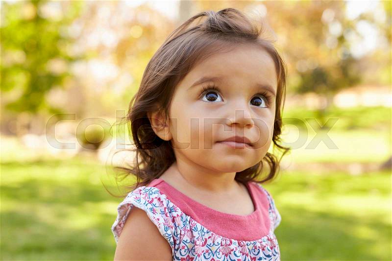 Mixed race Caucasian Asian toddler girl in a park, portrait, stock photo