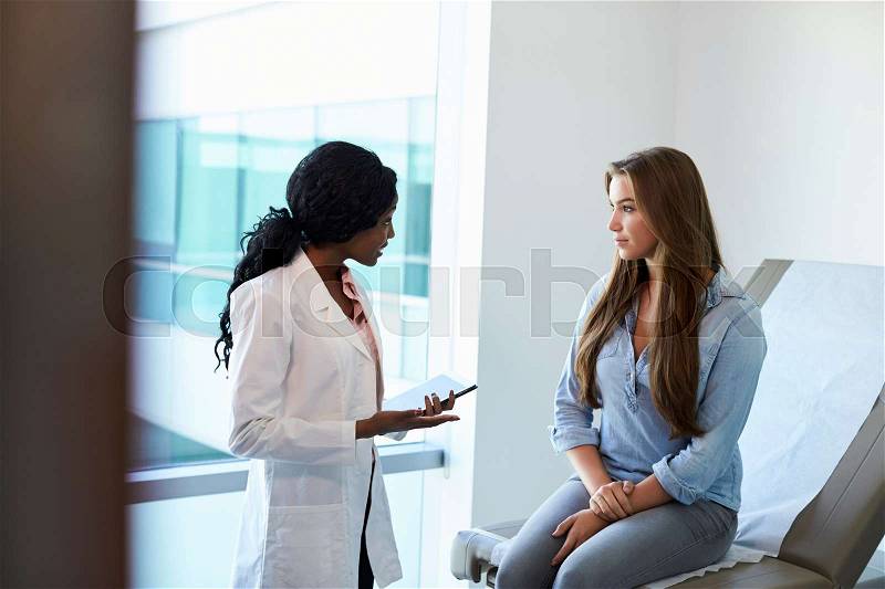 Female Doctor Meeting With Teenage Patient In Exam Room, stock photo
