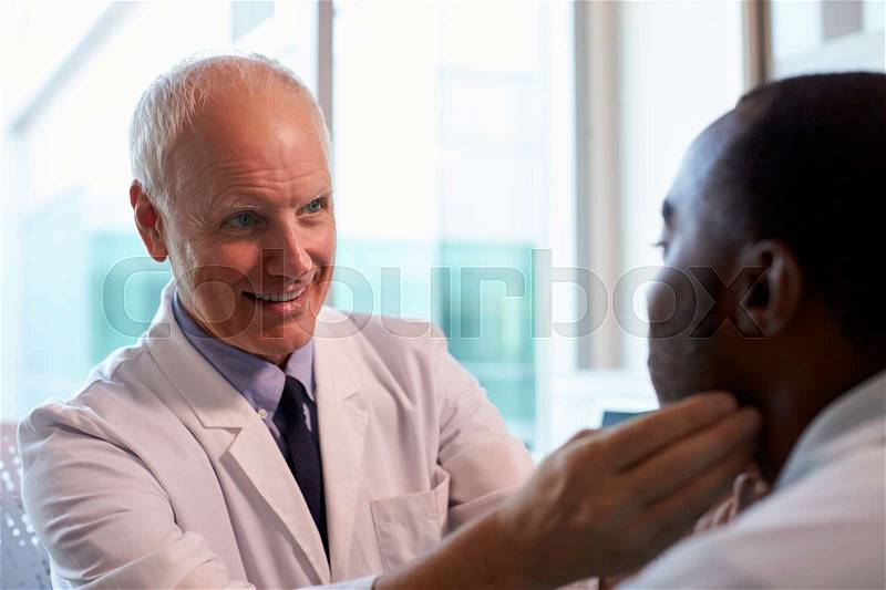 Doctor In White Coat Examining Male Patient In Office, stock photo