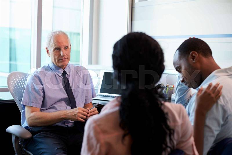 Doctor Treating Couple Suffering With Depression In Office, stock photo