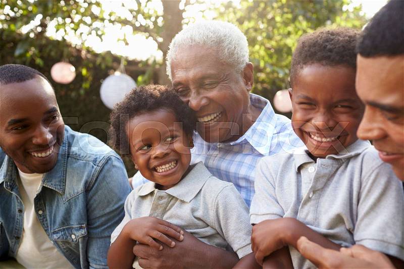 Multi generation male family members gathered in a garden, stock photo