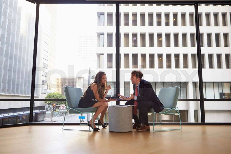 Businessman and woman meeting in modern office, full length, stock photo