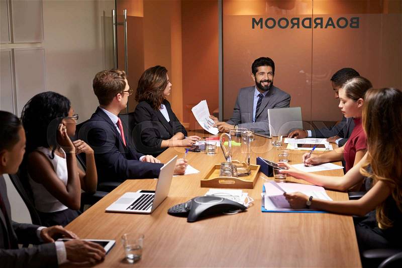 Corporate business people at an evening boardroom meeting, stock photo