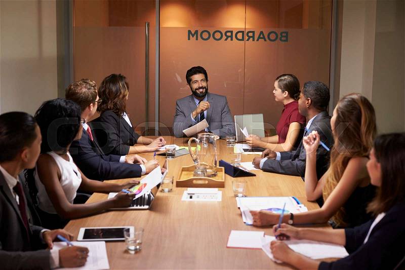 Corporate business people at an evening boardroom meeting, stock photo