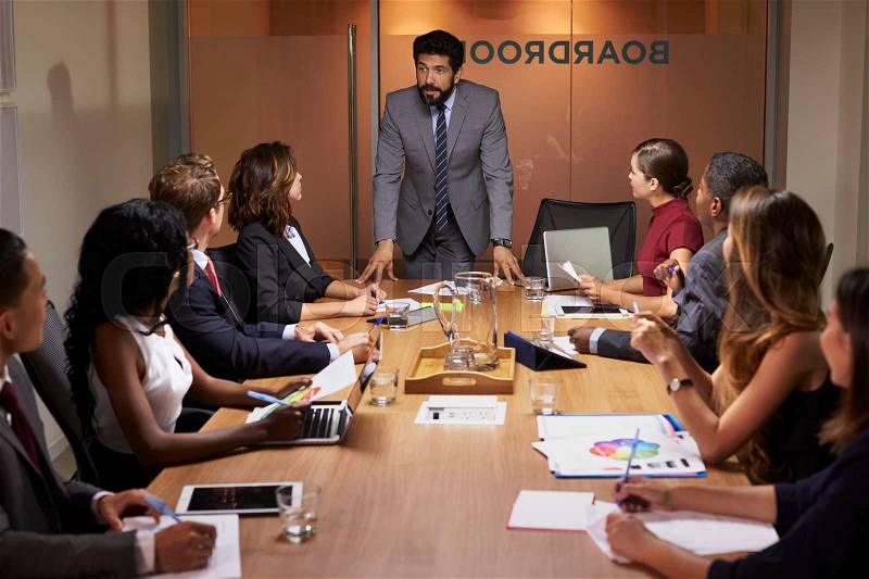 Businessman addressing colleagues at a boardroom meeting, stock photo