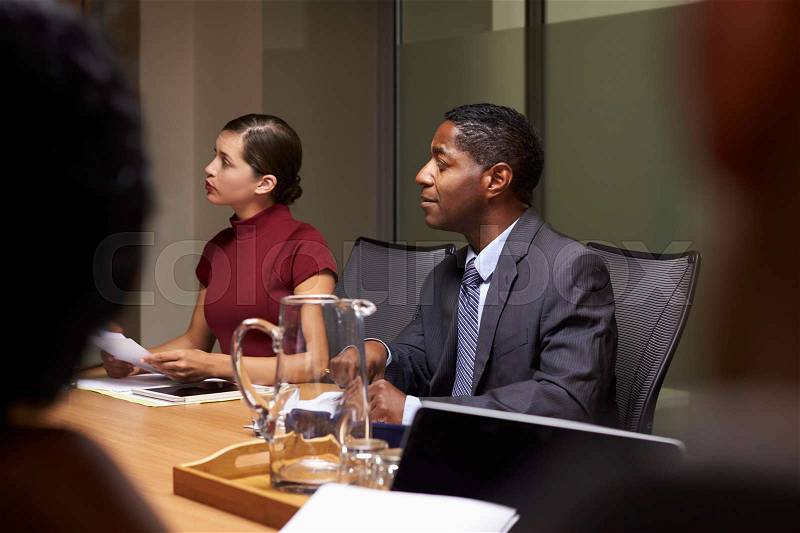 Business colleagues listening at boardroom meeting, close up, stock photo