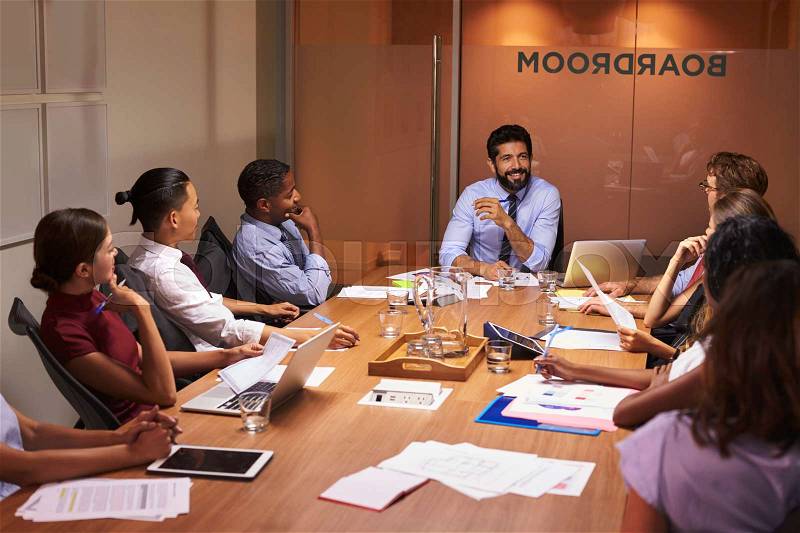 Business people listening to manager at a boardroom meeting, stock photo