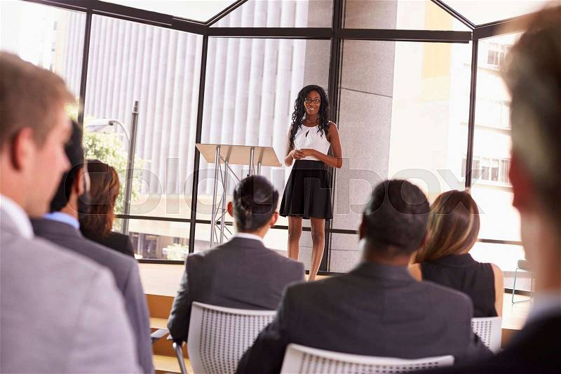 Young black businesswoman presenting seminar to an audience, stock photo
