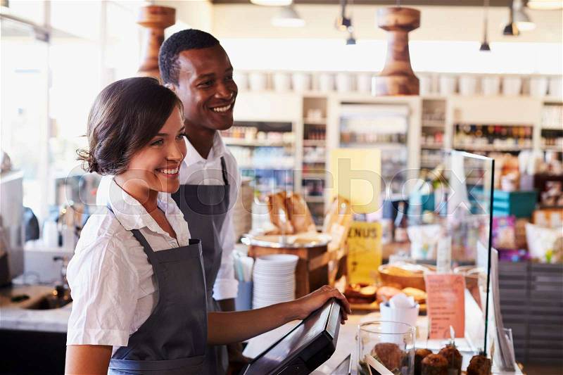 Staff Serving Customers At Delicatessen Checkout, stock photo