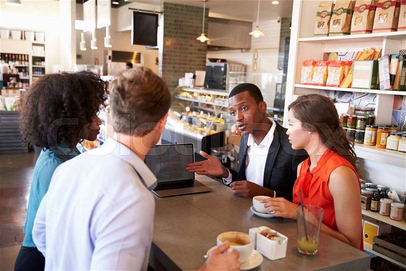 Business Group Having Informal Meeting In Cafe, stock photo