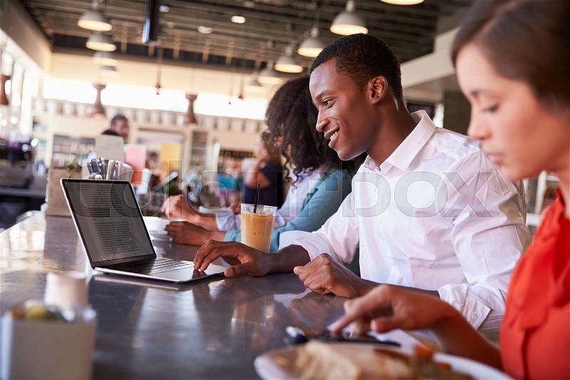 Business People Working At Counter In Coffee Shop, stock photo