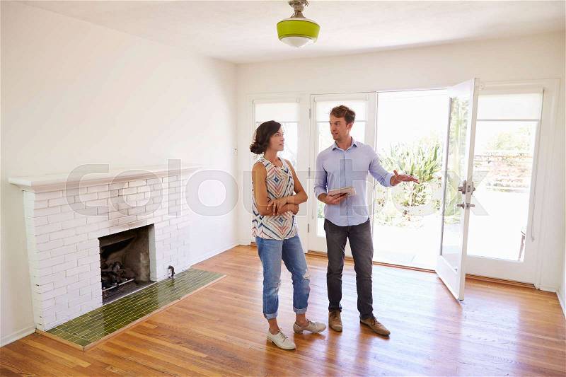 Male Realtor Showing Female Client Around House, stock photo