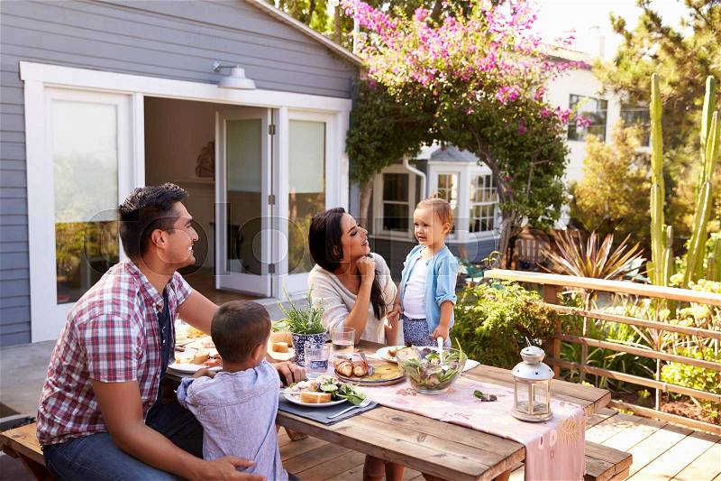 Family At Home Eating Outdoor Meal In Garden Together, stock photo