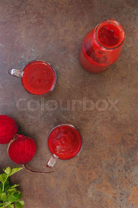 Roasted beet smoothie in bottle and glass. Top view, blank space, rustic surface, stock photo